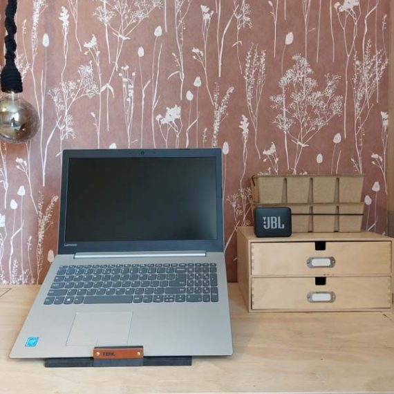 FBRK. Laptopstandaard Zwart, sfeerfoto met laptop vooraanzicht met roze bloemetjes achtergrond en JBL box